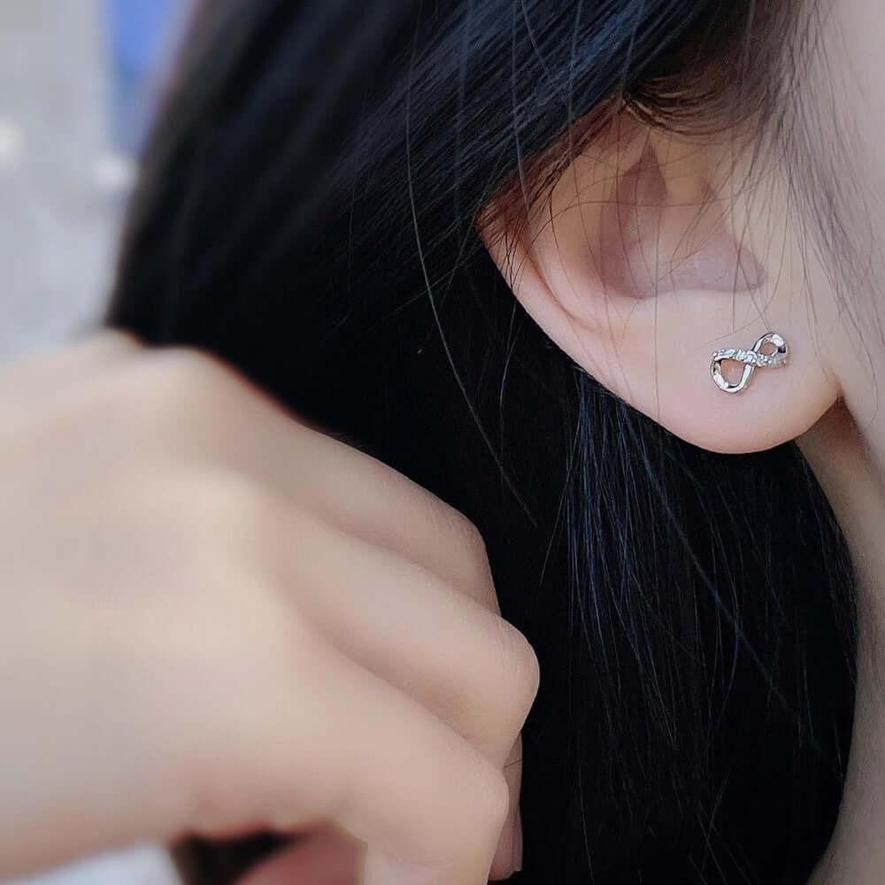 Сребърни обеци Безкрайност S925, стилен дизайн с безкрайна форма, носени от жена.