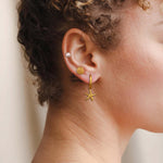 Сет морски обеци с 18К златно покритие, включващ звезда и перли, носени от жена.