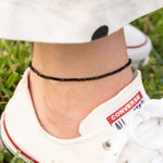 Гривна за глезен с черни мъниста, стилна и универсална, идеална за летни визии.