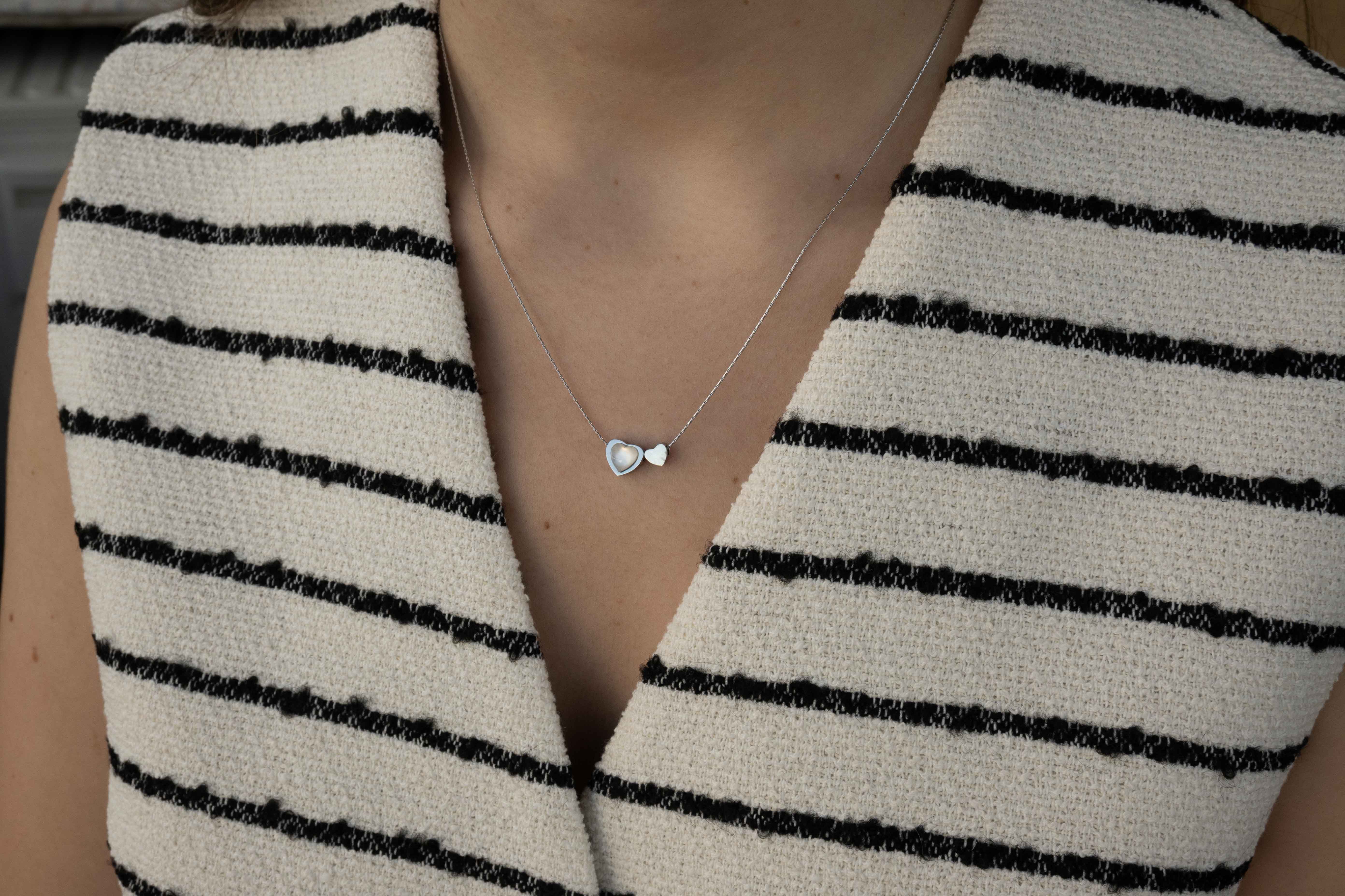 Двойно Колие Сърце със Седеф, носено от модел, на фона на раирана дреха.