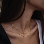 Изискано двойно златисто колие с 18К покритие, което подчертава стила и елегантността.