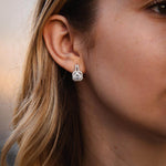 Елегантни обеци с блестящи камъни, изработени от сребро S925, носени от жена.