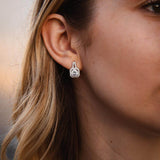 Елегантни обеци с блестящи камъни, изработени от сребро S925, носени от жена.