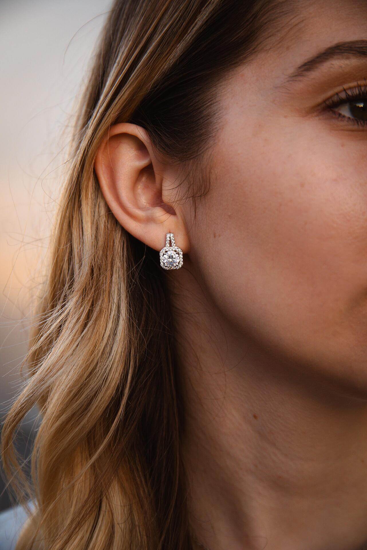 Елегантни обеци с блестящи камъни, изработени от сребро S925, носени от жена.