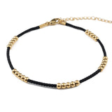 Black cord ankle bracelet with gold beads, made from medical steel, waterproof and stylish for daily wear.