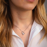 Сребърно колие с форма на сърце S925, носено от жена, с модерен и елегантен дизайн.