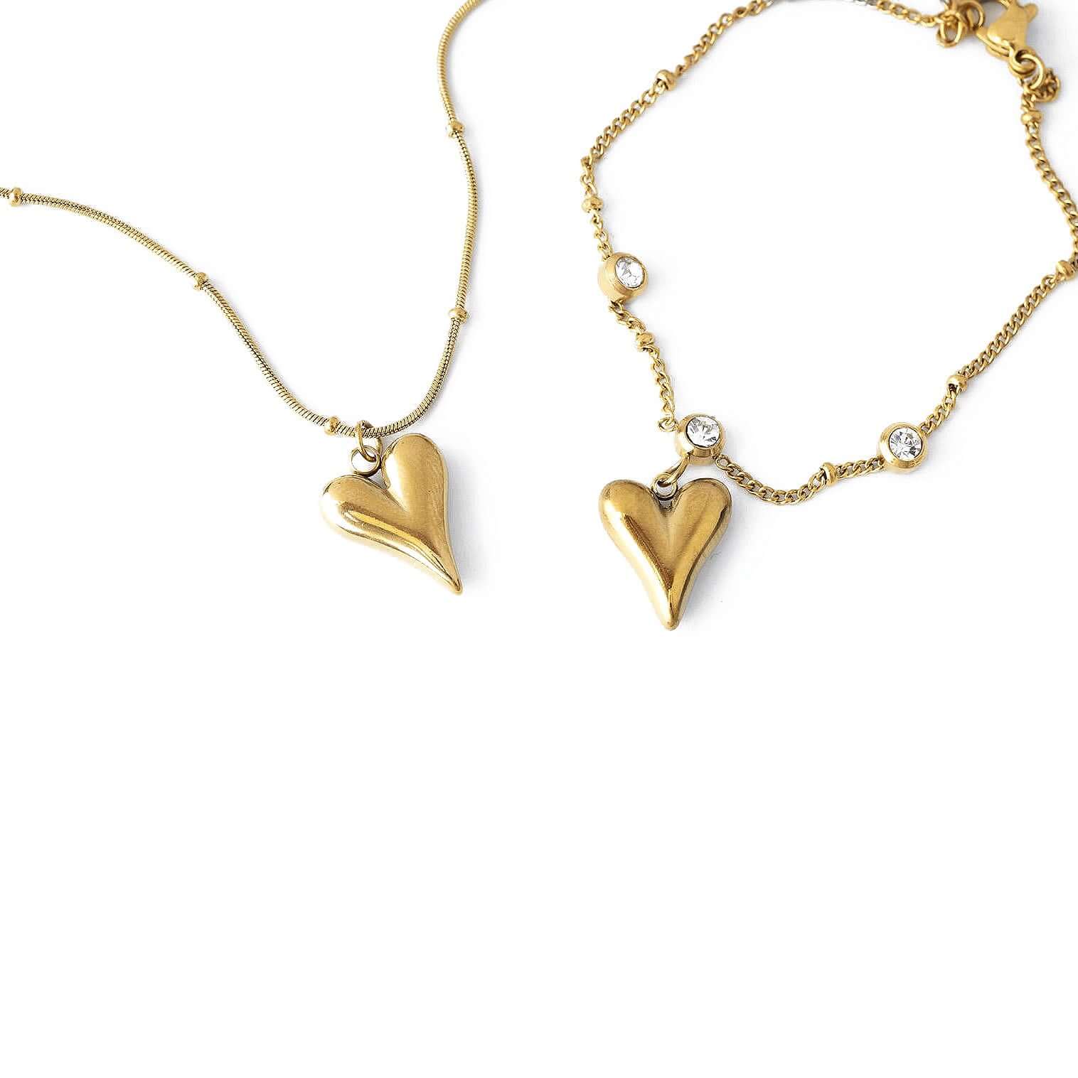 Златист комплект колие и гривна с висулки във формата на сърце, изработен от медицинска стомана.