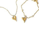 Златист комплект колие и гривна с висулки във формата на сърце, изработен от медицинска стомана.