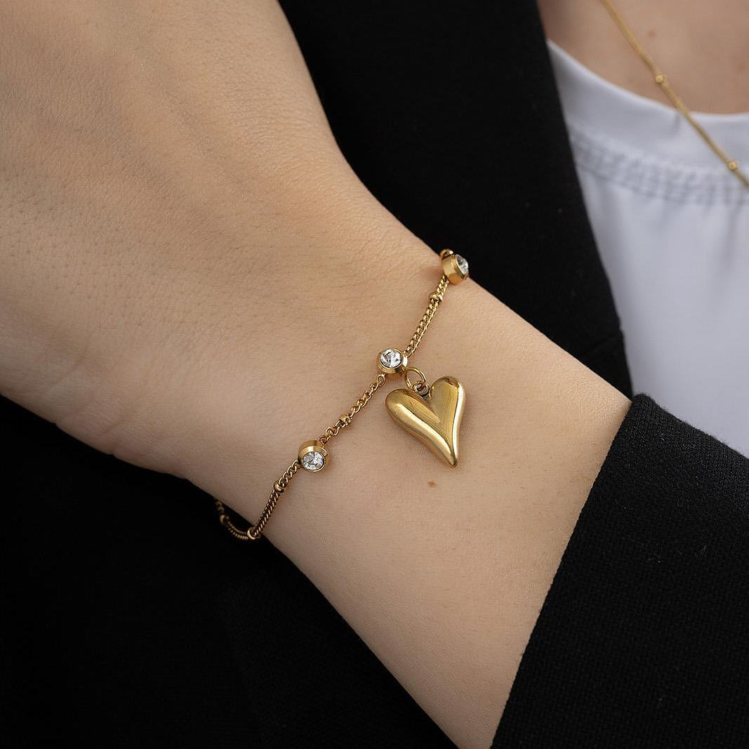 Мека зластиста гривна със сърце и кристали, идеален аксесоар за елегантна визия.