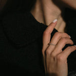 Изтънчени обеци V-Shape и стилен пръстен, носени от жена с елегантен аутфит.