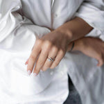 Woman wearing a shiny S925 silver ring with crystal and zirconia, posing in a stylish outfit.