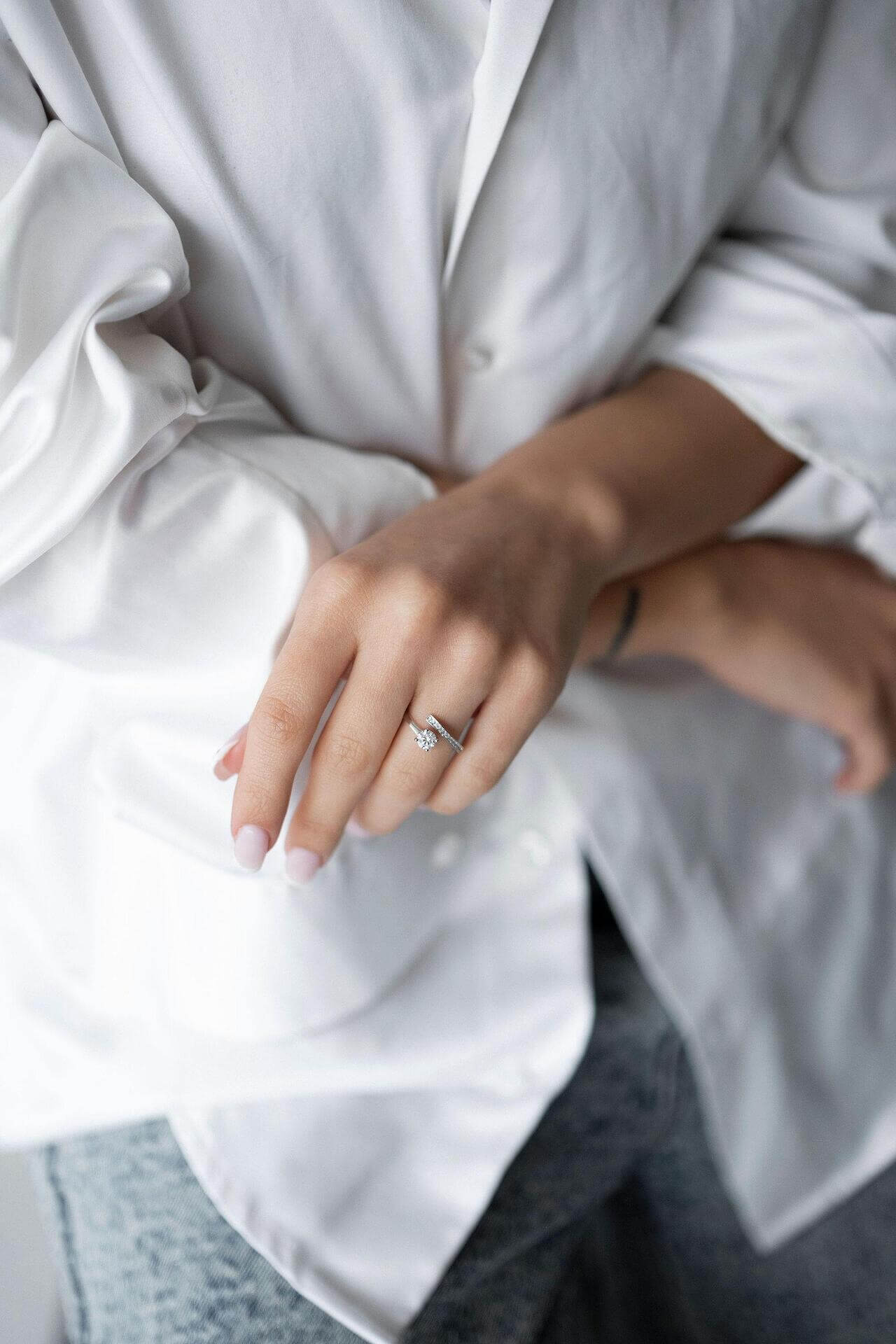 Woman wearing a shiny S925 silver ring with crystal and zirconia, posing in a stylish outfit.