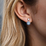 Сребърни обеци с окото на Хамса S925, носени от жена с дълга коса.