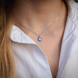 Сребърно колие с окото на Хамса, изработено от Сребро S925, носено на бяла риза.