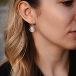 Висящи обеци с блестящи камъни и сребро S925, носени от жена с дълга коса.